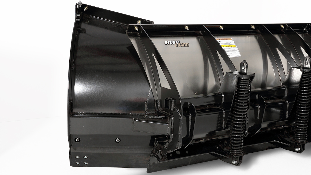 A close-up view of a black snow plow blade with heavy-duty springs and bolts, labeled Storm Guard, set against a plain white background.
