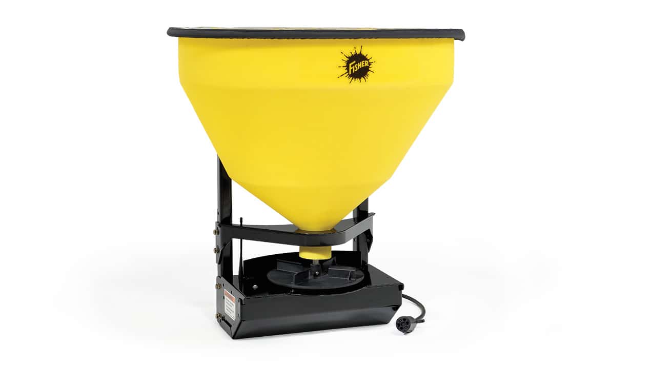 A yellow plastic broadcast spreader with a black base and an attached power cord, used for spreading materials like seed or fertilizer. The container is cone-shaped and has a logo with the word Fertil on the front.