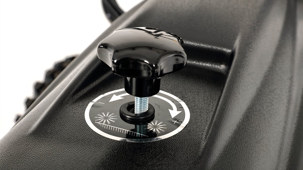 Close-up of a black plastic knob with a threaded metal shaft, mounted on a textured black surface. A circular label beneath shows directional arrows for tightening and loosening the knob.