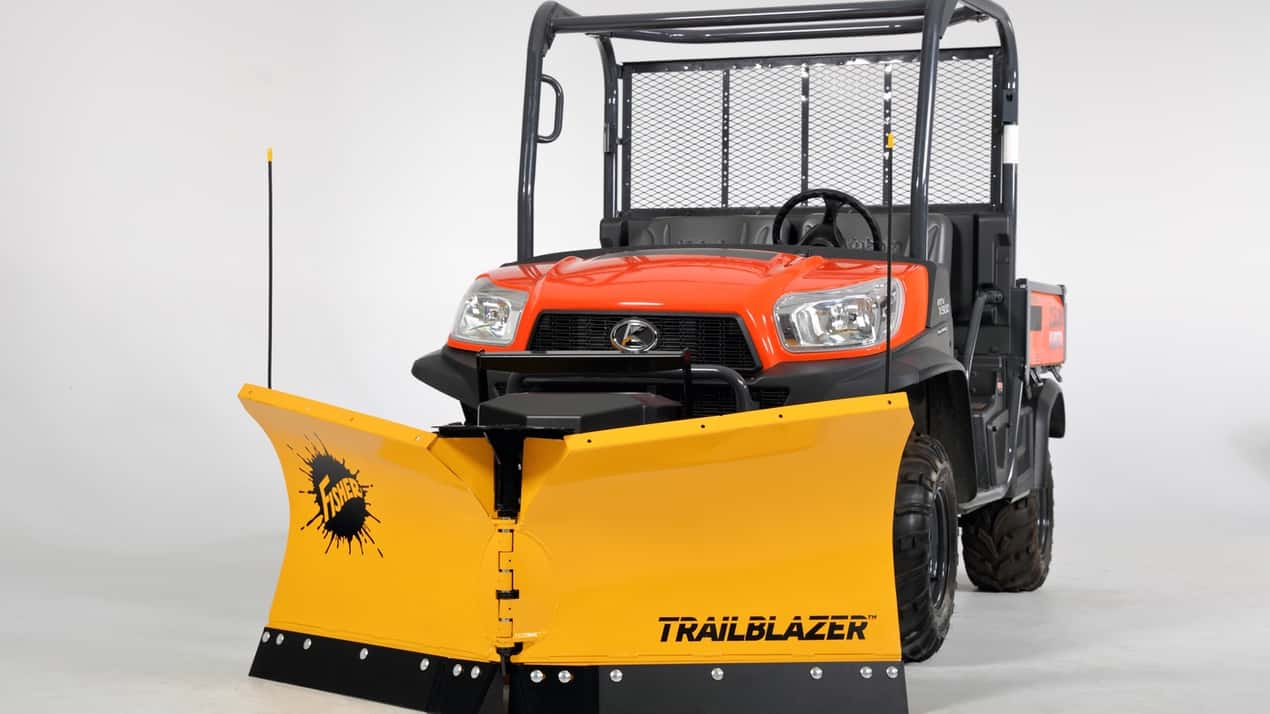 A utility vehicle with an orange and black exterior is equipped with a large yellow snow plow labeled TRAILBLAZER attached to the front, parked against a plain white background.