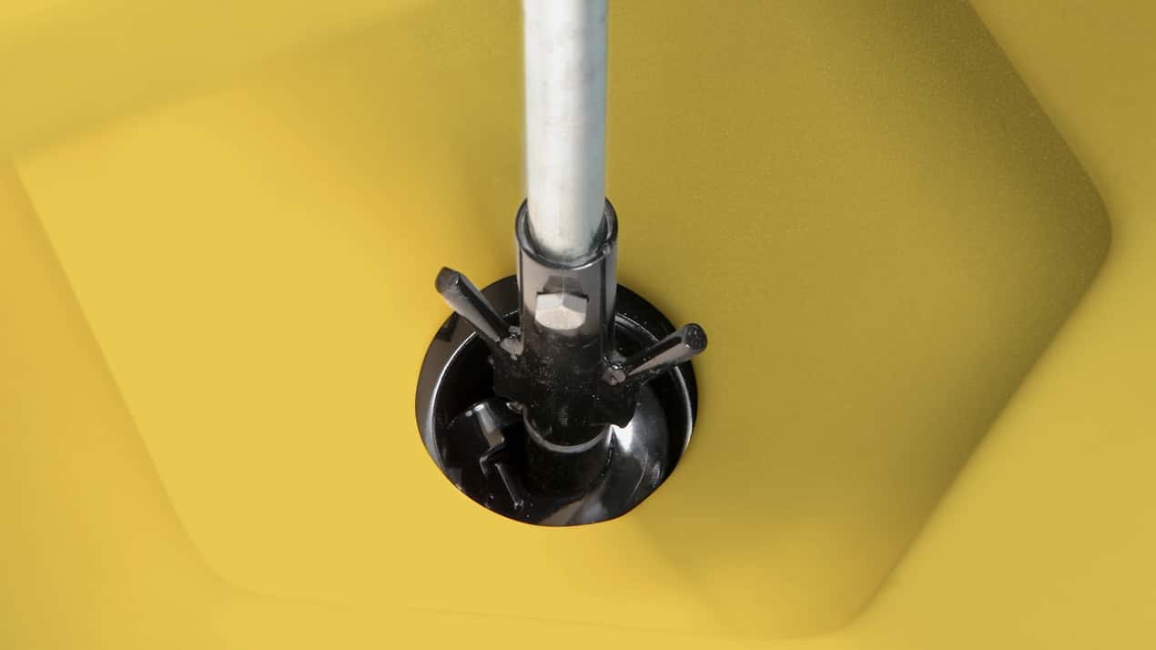 Close-up of a metal pole inserted into a black, circular mount with three bolts, set against a bright yellow, slightly textured background.