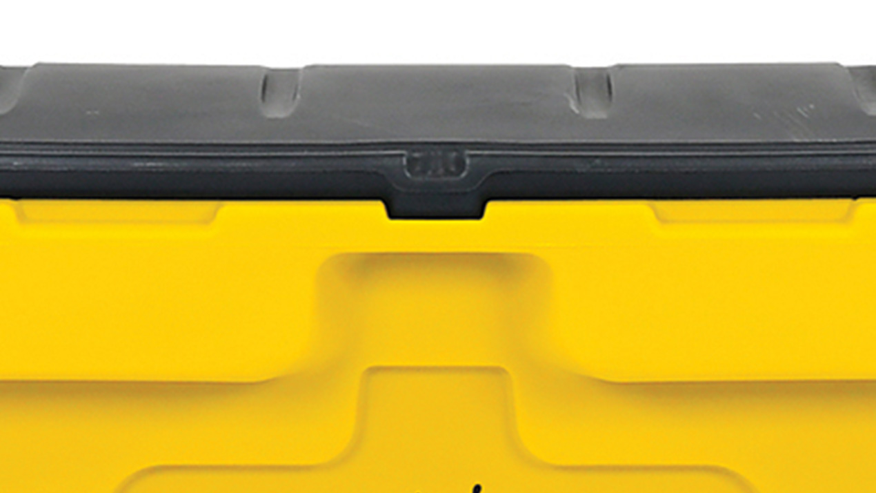 Close-up of the top section of a yellow and black plastic storage toolbox, showing the black lid and part of the yellow body with a central latch detail.